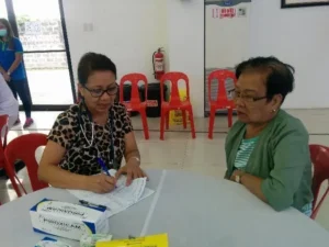 Healthcare worker assisting a patient with documents during a medical mission